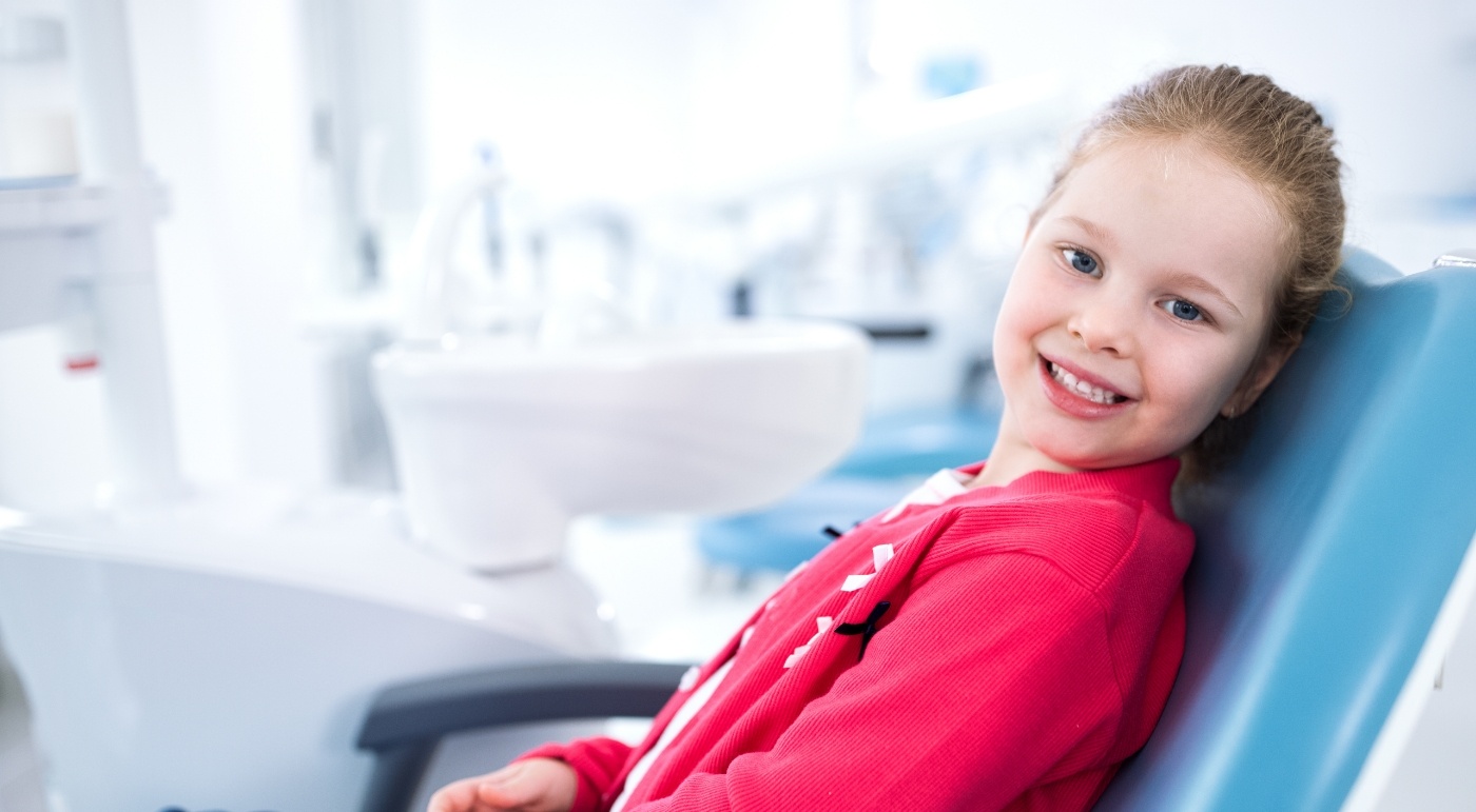 Child smiling during a visit with her children's dentist