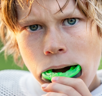 Teen placing a custom athletic mouthguard