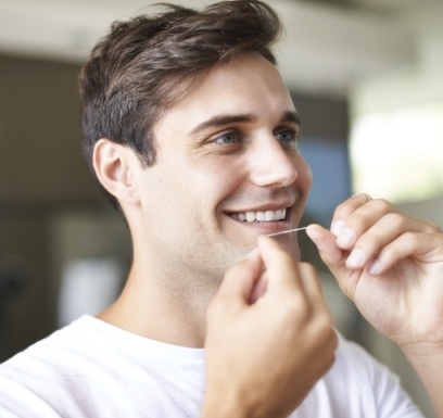 Man flossing teeth to prevent dental emergencies