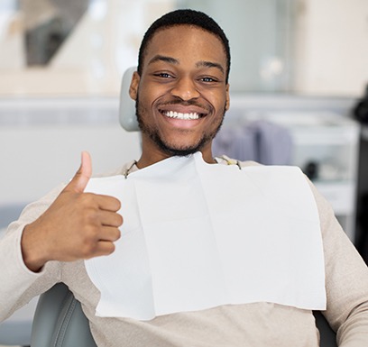 Male dental patient giving thumbs up