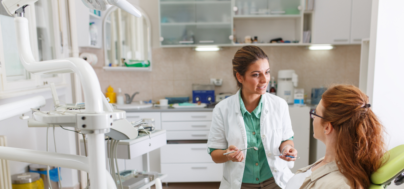 Dentist talking to female patient in dental chair