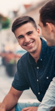 Smiling young man wearing navy blue short sleeved button up shirt