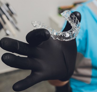 Dentist holding Invisalign® in Tulsa