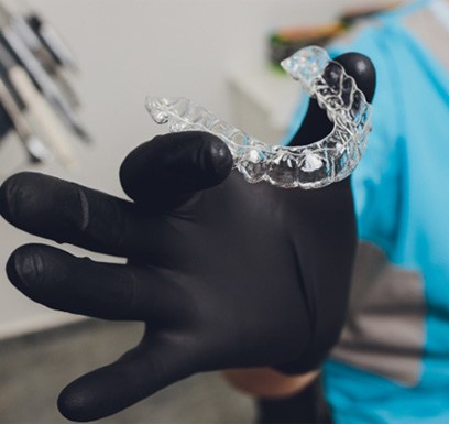 Dentist holding Invisalign® in Tulsa 