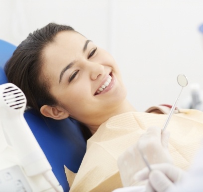 Woman smiling during dental checkup and teeth cleaning visit