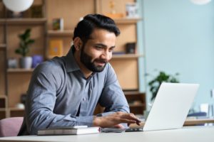 a man researching dental insurance plans on his laptop