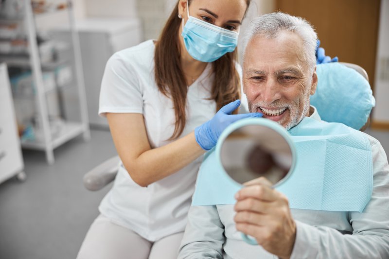 An aging senior happy with his new dental implants